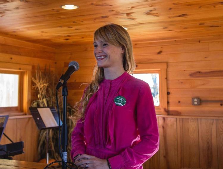 A photo of Tanya Vyhovsky standing at a podium and looking out at the audience